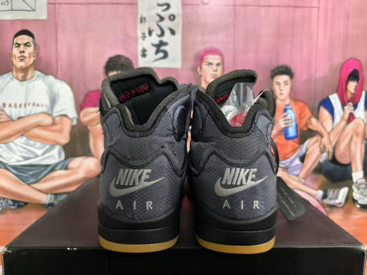 Rear view of grey and black high-top sneakers showing Nike Air branding, padded collars, and translucent yellow outsole accents.