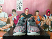Front view showing black laces, textured white uppers, and red and blue patterned detailing.