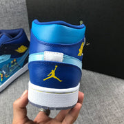 Rear close-up of the sneaker showing yellow Jumpman branding, blue heel panels and a white midsole.