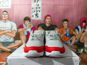 Front view of Nike Air Max Mind sneakers in white, gray, and red