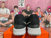 Rear view of the black and white basketball shoes, showing the heel straps and soles.