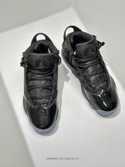 Top view showing a pair of black high-top sneakers with layered laces, padded tongues, and glossy toe panels.