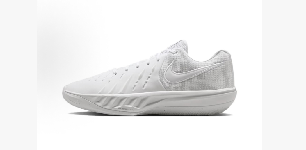 White Nike low-top basketball sneaker shown from the side, featuring a perforated forefoot, padded collar, visible Swoosh, and textured outsole.