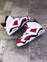 Pair of red, white, and black high-top sneakers arranged on a tiled surface.