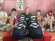 Front view of white and dark blue Nike sneakers with dark laces, layered panels, and textured tongues.