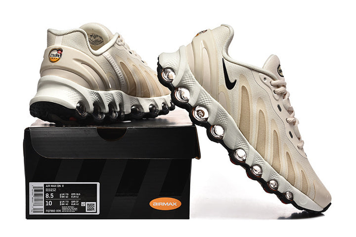 Cream and beige Nike Air Max DN sneakers shown from multiple angles beside a shoe box