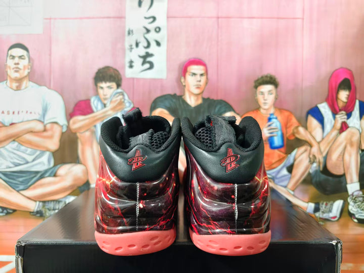 Rear view of red-and-black Nike Foamposite sneakers with coral-pink outsoles