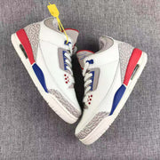 Side view of the pair showing the high-top profile, patterned grey panels, red heel sections, and blue midsole accents.