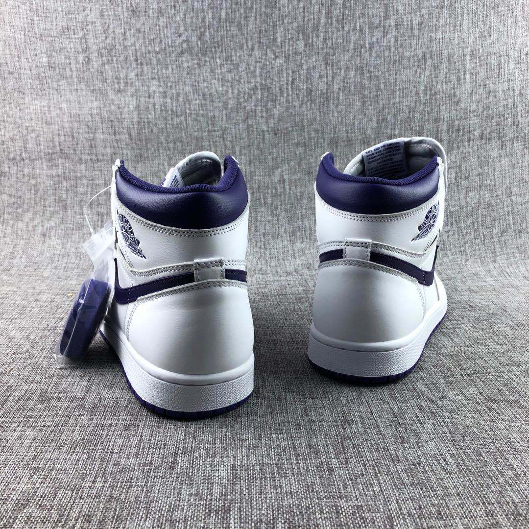 Rear view of white and purple Jordan high-top sneakers showing the padded collars, heel panels, and purple outsoles.