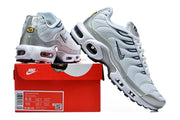Nike Air Max Plus sneakers in pale blue-white and metallic silver shown with a Nike shoe box; the box label shows Air Max Plus and a sample size.