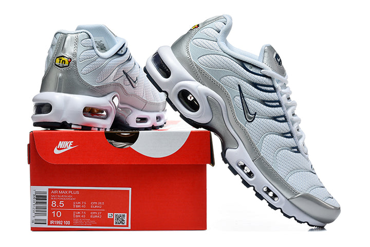 Nike Air Max Plus sneakers in pale blue-white and metallic silver shown with a Nike shoe box; the box label shows Air Max Plus and a sample size.