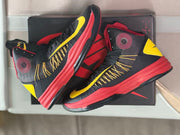 Pair of high-top basketball shoes arranged on a dark shoe box