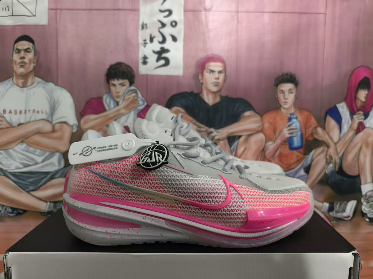 Grey and pink Nike basketball shoe shown from the side