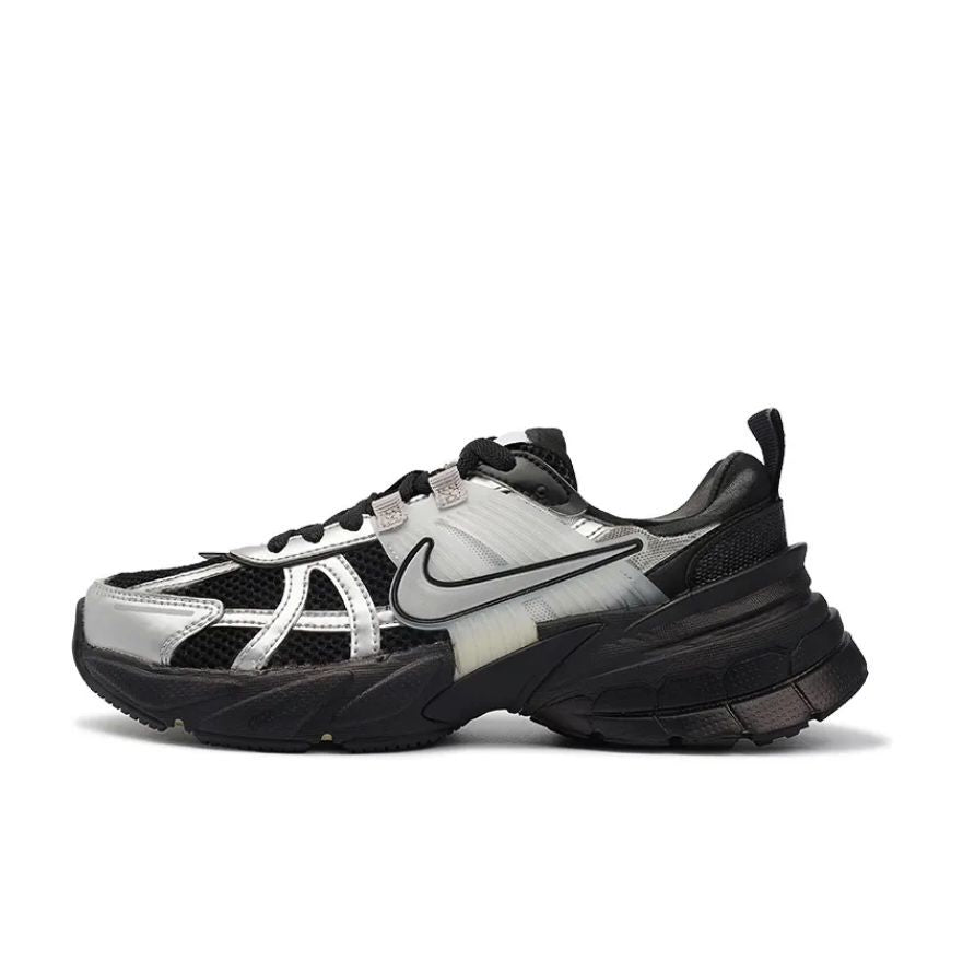 Side view of a black and silver Nike Zoom Vomero 5 sneaker with layered panels, mesh sections, and a chunky black sole.
