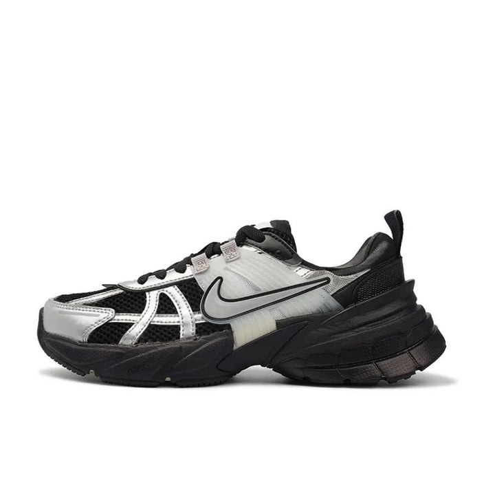 Side view of a black and silver Nike Zoom Vomero 5 sneaker with layered panels, mesh sections, and a chunky black sole.