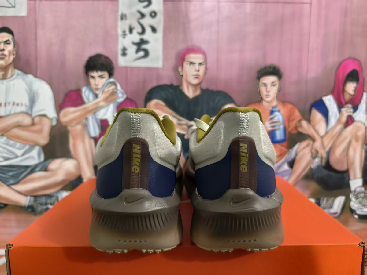 Rear view of Nike running shoes in brown, gray, cream, and navy with visible heel branding.