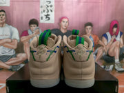 Rear view showing padded beige heel sections, green pull tabs, patterned details, and visible heel branding.