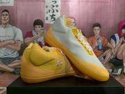 Angled view of the yellow and white Converse sneakers displayed together.