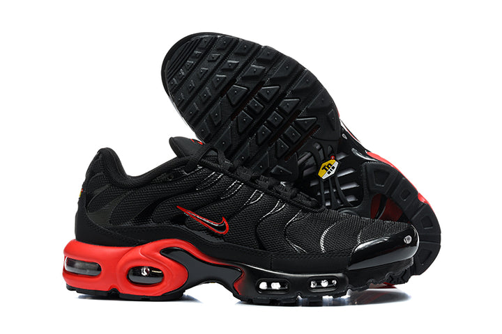 Black and red Nike Air Max Plus sneakers shown from the side with one shoe turned to display the outsole.