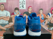 Rear view of blue Nike Kobe shoes with red heel signatures and white midsoles.