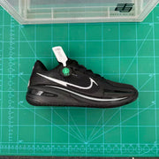 Single black sneaker shown in profile on a green measurement mat, with silver side branding and a patterned outsole.
