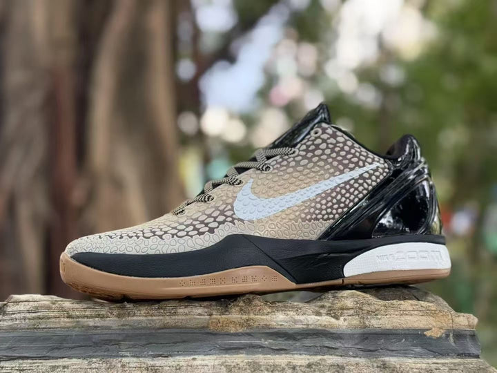 Side view of Nike Kobe 6 sneakers showing the beige patterned upper, light Swoosh, black midsole, and gum outsole.