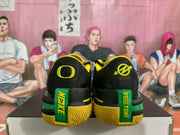 Rear view of black basketball sneakers with yellow and green accents, displayed on a shoe box.