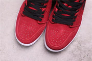 Close-up of the perforated red toe boxes and black laces.