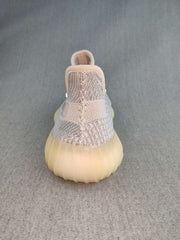 Rear view of a Yeezy 350 V2 style sneaker showing the knit heel, pull tab, and translucent gum-colored sole.