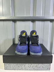 Front view of a pair of purple Jordan Air Jordan 4 sneakers with black laces and yellow tongue logos.