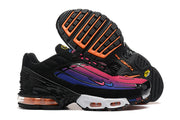 Side and outsole views of black sneakers with pink and purple gradient panels, white midsole sections, and orange accents.