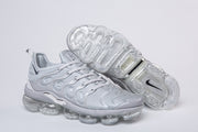 Silver-gray Nike TN-4 sneaker pair with clear segmented soles visible