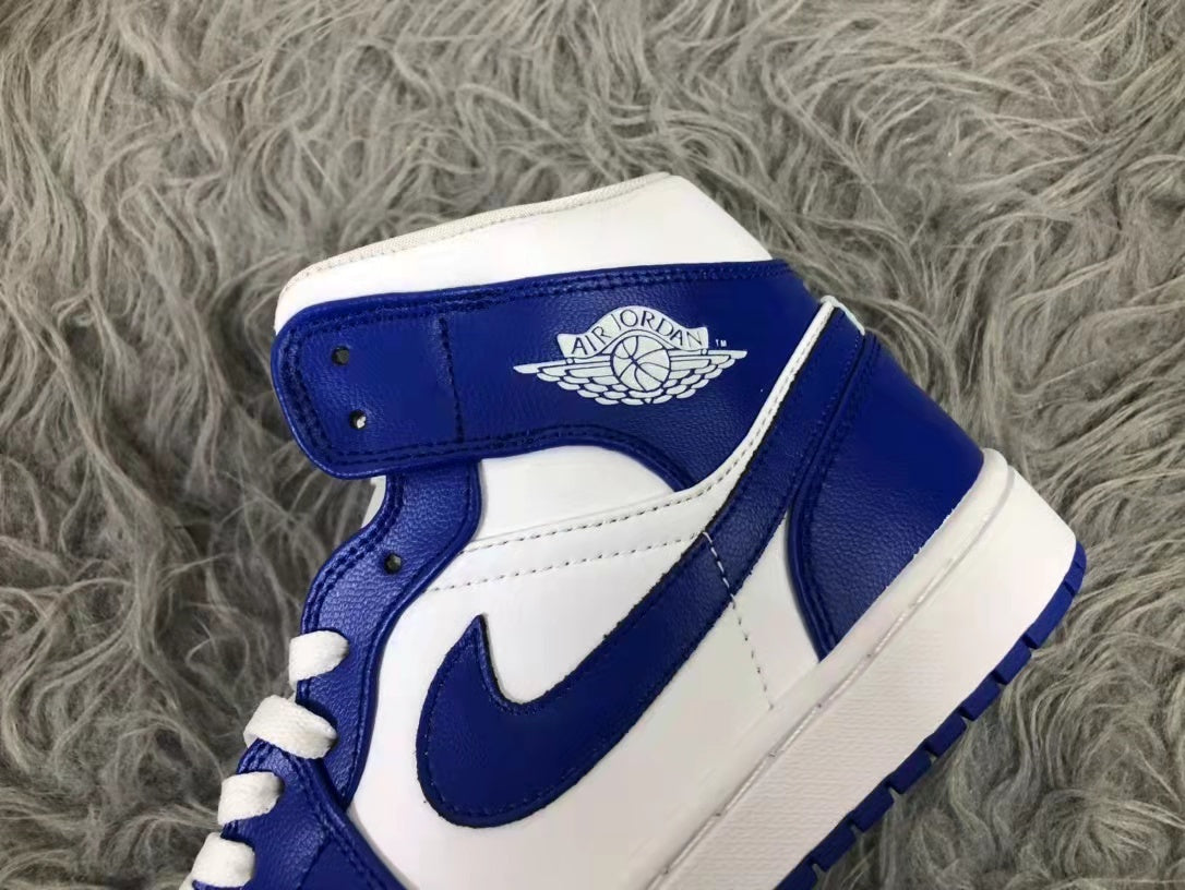 Close-up of the white and blue mid-top sneaker showing the collar branding, blue Swoosh, white panels, and white laces.