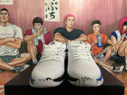 Front view of a pair of white lace-up basketball shoes with blue and black accents.