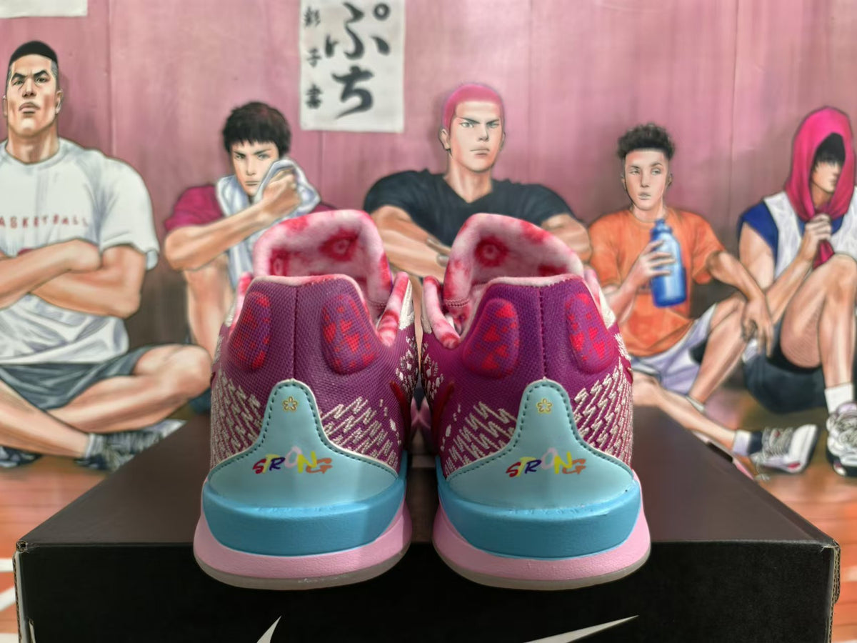 Rear view of purple, pink, and blue Nike basketball shoes with patterned panels and colorful heel details.