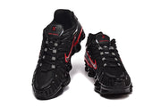 Pair of black and red Nike Shox TL sneakers viewed from the front.