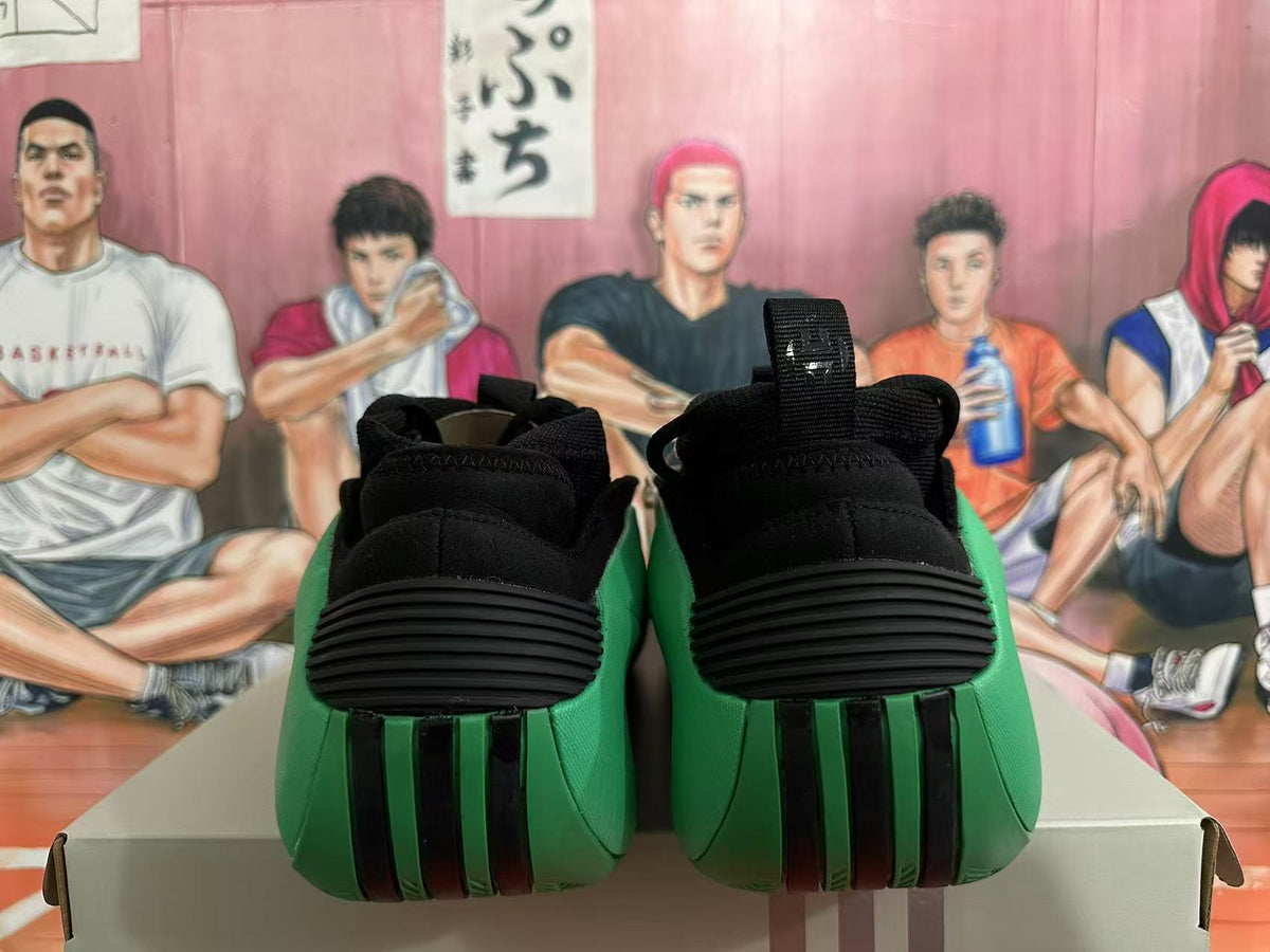 Rear view of black sneakers with green panels and ribbed heel details