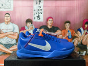 Side view of a blue Nike Kobe basketball shoe with white Swoosh and red stitching.