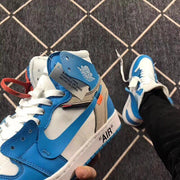 Close-up of the ankle area showing the winged logo, layered panels, alternate laces, and a visible manufacturing tag.