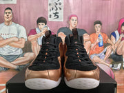 Front view showing the black laces, tongue panels, bronze toe sections, and white outsoles.
