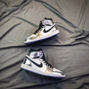 Two white and silver high-top sneakers arranged on a gray surface.