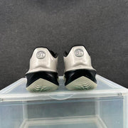 Rear view of the metallic silver sneakers showing black heel sections and circular GT emblems.