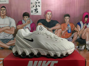 Side profile of a white Nike Air Max sneaker showing the black Swoosh and segmented sole with rounded visible elements.