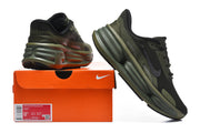 Olive and black Nike running shoes displayed beside an orange shoe box; the label shows a sample size of US men's 8.5.