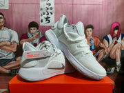 White Nike shoes arranged at an angle, showing the side Swoosh, lace-up design, and outsole tread.