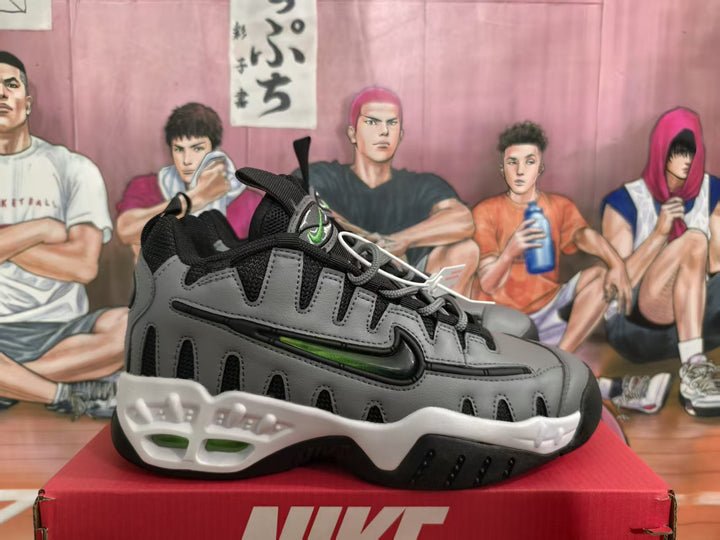 Side view of grey and black Nike sneakers with green accents and a white sculpted midsole