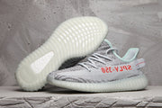 Pair of gray and white Yeezy 350 V2 sneakers showing the patterned upper and translucent ribbed outsoles.