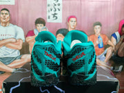 Rear view of the sneakers showing green heel panels with black detailing and red “TWELVE” lettering.
