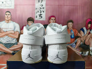 Rear view of the white shoes showing ankle straps and Jumpman heel logos.