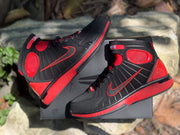 Top-down view of the sneaker pair arranged over a black shoebox.